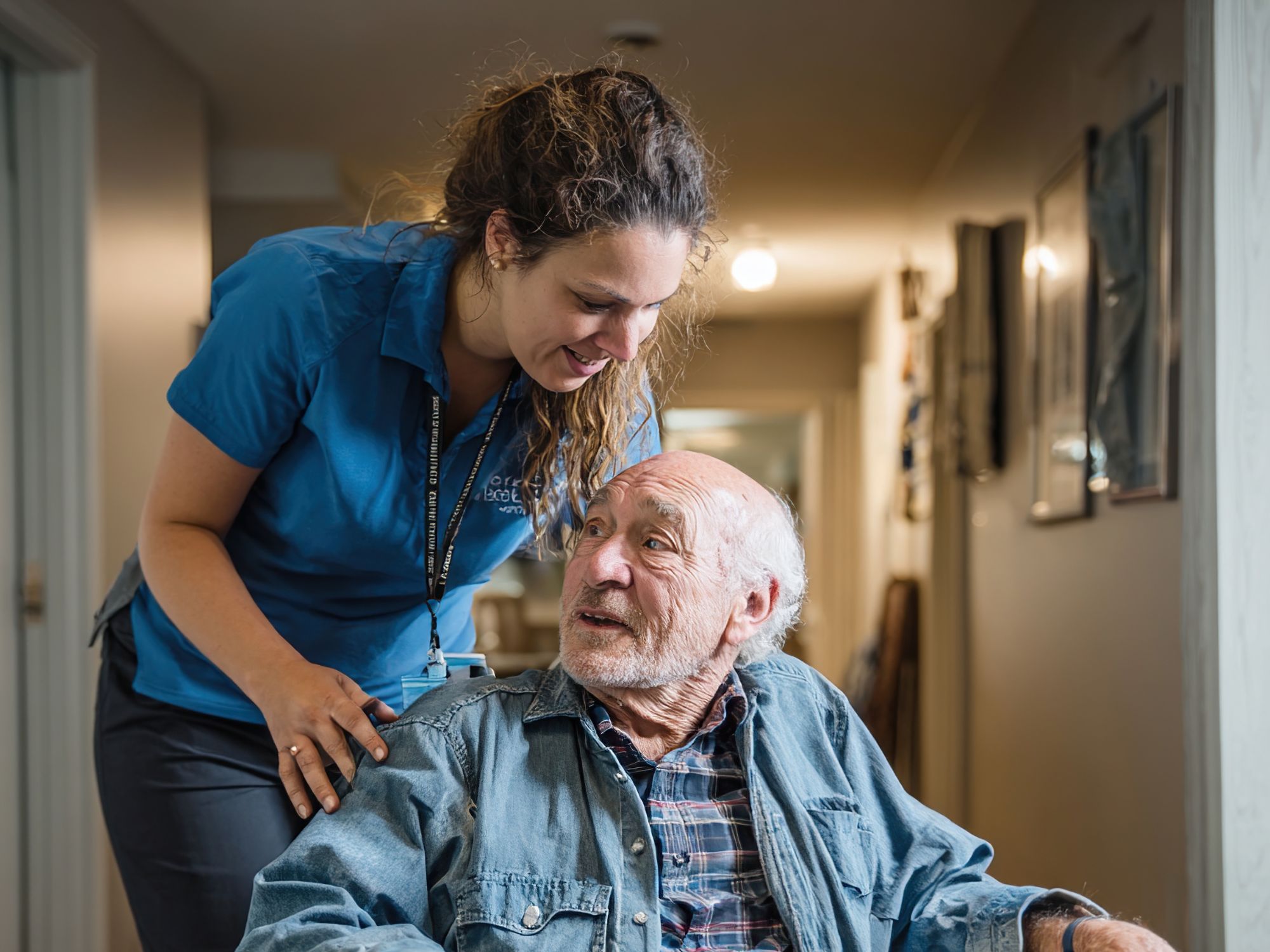 Caregiver helping elderly resident in senior living location